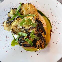 Grilled cauliflower that set in smoke, almond sesame sauce, mint citrus oil