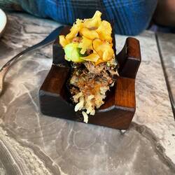 Oxtail taco with rice, potato chips, melon ice cream flavor dollop, seaweed wrap