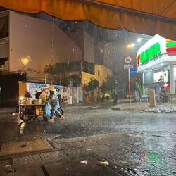 Vendor braves the rain outside Warning Zone 76