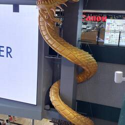 Dieser goldige (??) Zeitgenosse weist auf das im Hintergrund sichtbare Hotpot-Restaurant hin