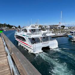 The captain standing on the port deck, is remotely controlling the boat for docking.