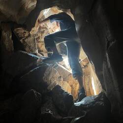 Dan climbs through a Marble Mountain cave