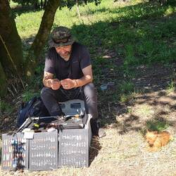 Joa and his dog, selling earrings by the path.