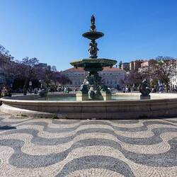 Ansicht des Rossio mit dem Teatro Dona Maria II, den Bronzespringbrunnen und der Statue Pedros IV.