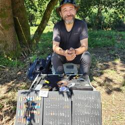 Jorge selling earrings with his yorky dog.