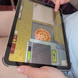 Das Kind spielt Pizzaservice auf dem iPad