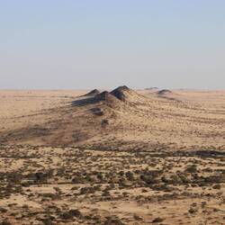 ...auf die flache Ebene und die Berge der Spitzkoppe