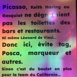 Not sure what this says but probably entertaining poster in bathroom