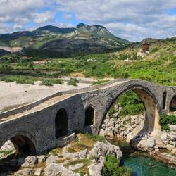Eine schöne ale Brücke und im Hintergrund die Albanischen Alpen