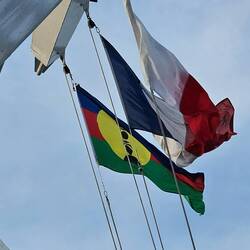 Flags of New Caledonia and France, along with a pilot onboard flag.