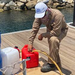 Roman feeds clean fuel into the tanks for flushing.