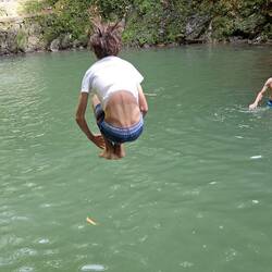 Thomas launches into the pool with a cannonball.