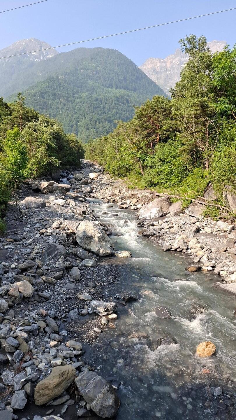 Een bergrivier vol smeltwater ruist naar de rustigere Rhône