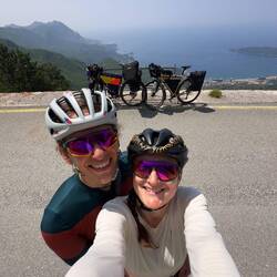 Sveti Stefan im Hintergrund von zwei sweaty Radfahrern.