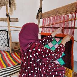 Woman demonstrating amazigh rug weaving