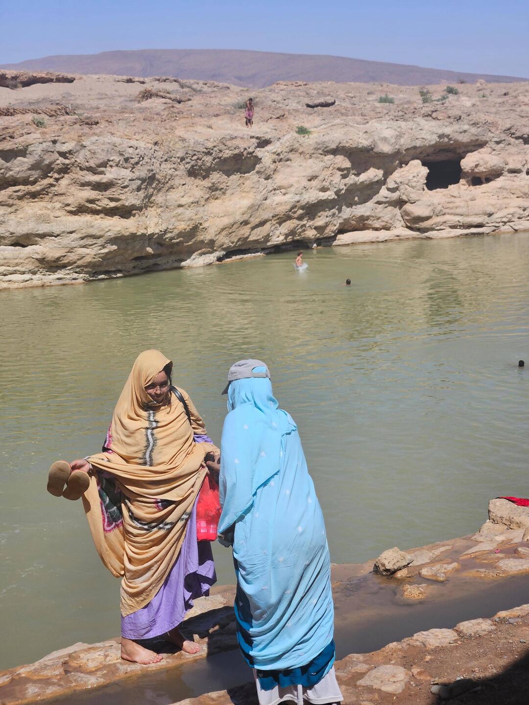 Women wearing a haik: a large piece of cloth that protects from sun and provides modesty