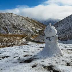 Wee snowman, with the road just about to descend in the background.