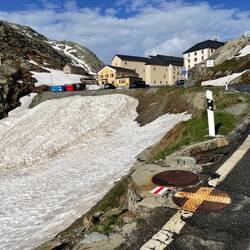 The trail is just to the left of the road marker