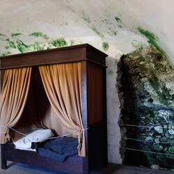 Slaapkamer priester met wand van de grot. Gevolg schimmel (groen)