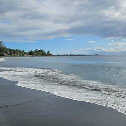 Black sand beach with Liz, Linda, and David in the water.