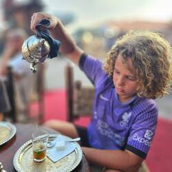 In Morocco, pouring tea from a height is what's done. It creates a frothy top, and shows hospitality