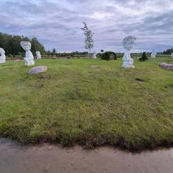 Insel mit Skulpturen und im Wasser verschiedene Seerosen.