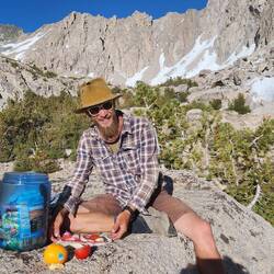 Tramp, fixing up a trail delicacy with fresh salami, cheese, and tomatoes.