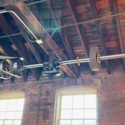 Belt and Pulley Line Shaft drive system. Clever use of cardboard discs to keep the shafts clean.