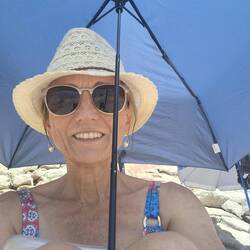 I'm the weirdo on the beach crouched under a mini umbrella for sun protection!