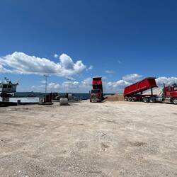 Arnold Transit barge bringing in some dumptrucks with sand