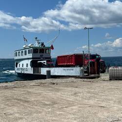 Arnold Transit barge bringing in some dumptrucks with sand