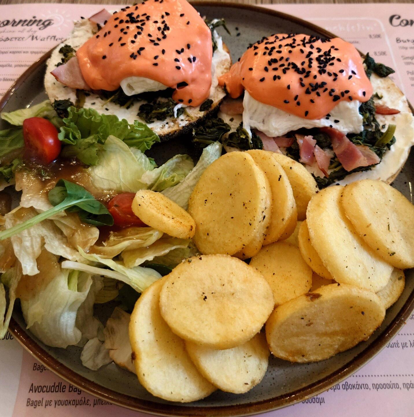 Red Eggvolution - bagel cream cheese, spinach, bacon, poached eggs red hollandaise and black sesame