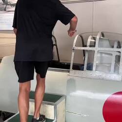 Jeff (wearing cool aviator glasses) folding himself into the zero fighter cockpit.