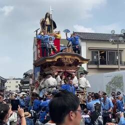 A yamahoko crew performing a dance at the entrance of the Naritasan Shinshoji.