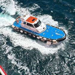 Ein kleines Boot besucht uns kurz vor der Einfahrt in den Hafen. Jemand springt auf