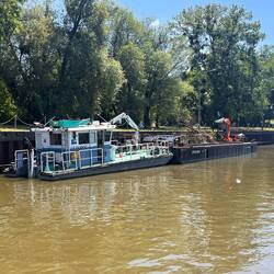 Arbeitsschiff mit Treibholz-Baum vor der Schleuse Blènot