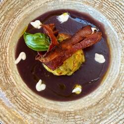 Broccoli flan with purple potato cream, goat cheese, and crispy bacon