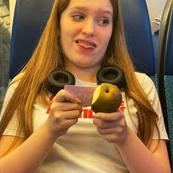 Allegra eating a pear with a saga card