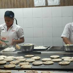 In a local restaurant, employees producing pupusas, the national dish of El Salvador.