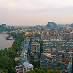 Au sommet de la colline, on aperçoit la ville, le fleuve Lijiang et les premiers blocs kharstiques