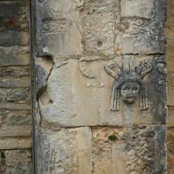 Another reused stone, a masked actor perhaps from the theatre