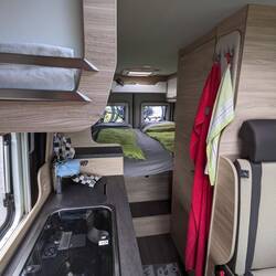 Einblick in den Camper: kleine Küche, Kühlschrank, Bad, Sitzecke und ein gemütliches Bett 🛌🏼😴