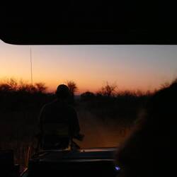 Spotter sits on a perch on the front bumper with a flashlight
