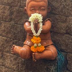 Dépôt de fleur sur une petite statuette de notre guesthouse, pour nos disparus