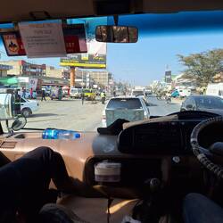 People, bikes, tuktuks, cars and dust