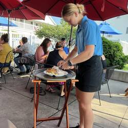 One of the wait staff deboning the boiled fish.