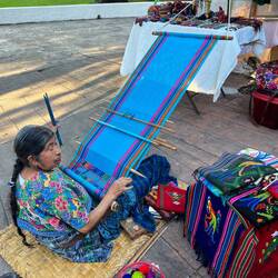 We bought placemats and a table runner from this woman weaving by the dock
