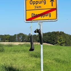 An einigen Ortseingangs und Ortsausgangsschilder hängen Stiefel. Warum?