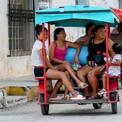 Passengers of a makeshift vehicle. Notice the cables and wires touching the ground.