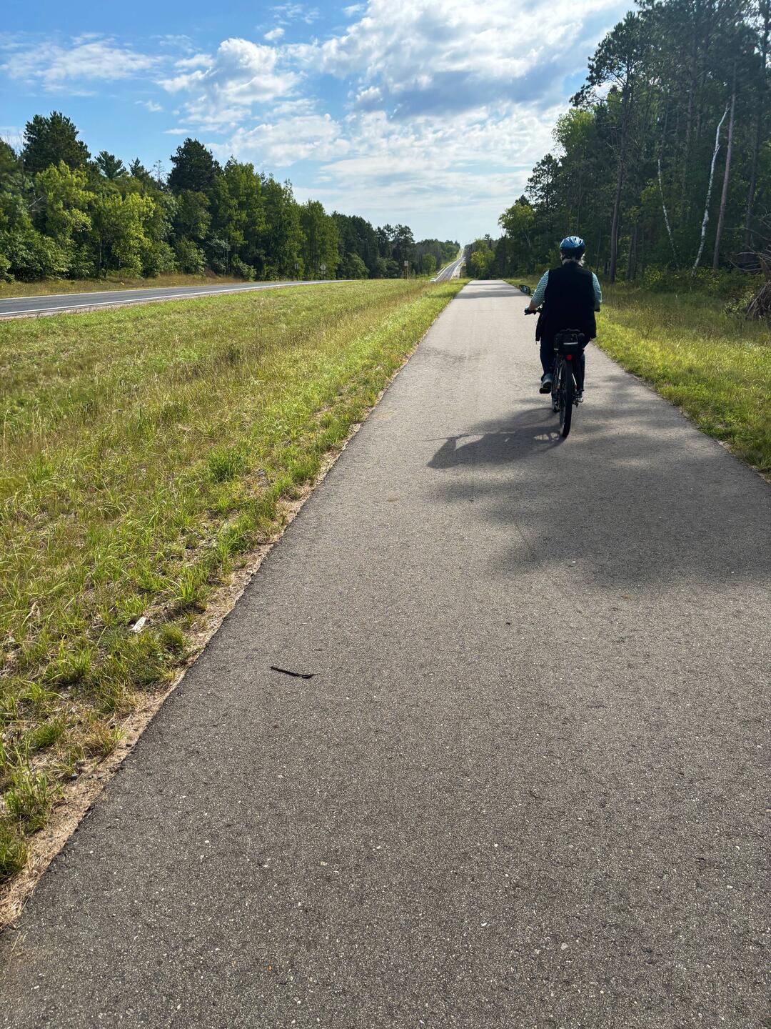 Jill rides ahead on the trail just outside Lake Bemidji Stsre Park